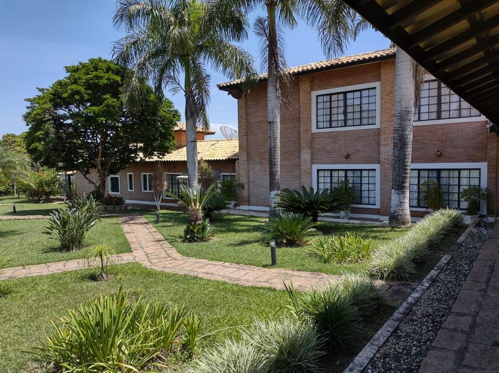 Fachada da casa em tijolo aparente com esquadrias escuras